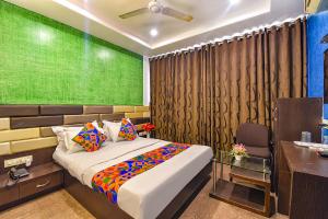 a bedroom with a bed and a desk and a desk at FabExpress Silver Plaza in Ahmedabad