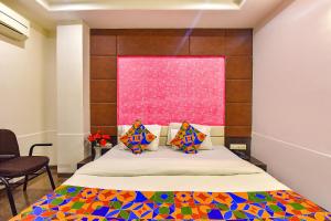 um quarto com uma cama e uma janela cor-de-rosa em FabExpress Silver Plaza em Ahmedabad