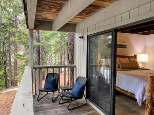 キングスビーチにあるWoodsy retreat near Northstar & lakeの椅子2脚とベッド1台付きのデッキが備わる客室です。