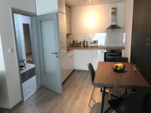 Šamorín modern apartmens في شامورين: مطبخ مع طاولة عليها صحن من الفواكه
