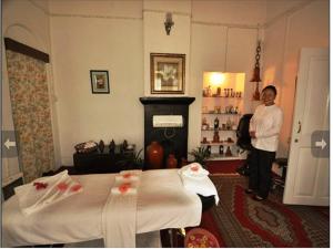 a man standing in a hotel room with a bed at Windamere Hotel - A Colonial Heritage Since 1841 in Darjeeling