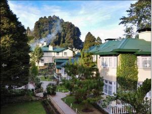a group of buildings with a mountain in the background at Windamere Hotel - A Colonial Heritage Since 1841 in Darjeeling +2 photos