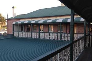 a brick building with a green roof and a deck at Central Hotel Stroud in Stroud