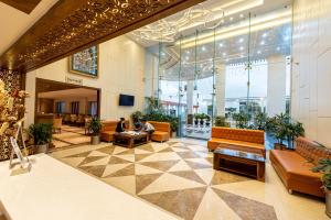 a lobby with couches and plants in a building at The Elite Lucknow Convention Hotel in Lucknow