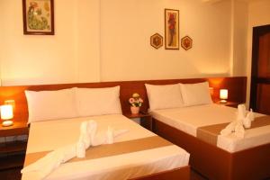 2 Betten in einem Hotelzimmer mit Handtüchern darauf in der Unterkunft Casa Belina in Puerto Princesa