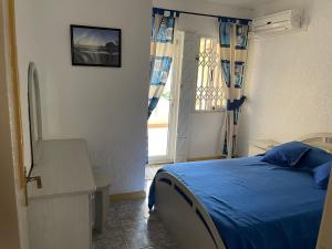 a bedroom with a bed and a table and a window at Villa Dreamteam in Flic-en-Flac
