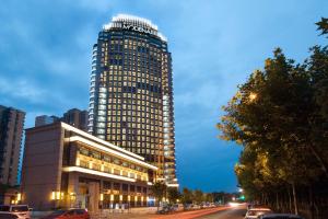 un grand bâtiment avec beaucoup de fenêtres sur une rue dans l'établissement Modena by Fraser Zhuankou Wuhan, à Wuhan