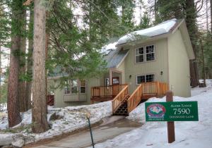 a house with a sign in front of it in the snow at Alder Lodge in Yosemite West