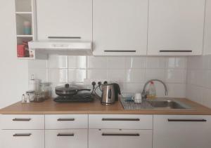 a kitchen with white cabinets and a sink at Studio Room Ensuite by the Beach, Entire Independent Unit in Limassol