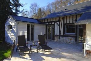 een patio met 2 stoelen en een huis bij Cottage, Vinnerville in Vinnemerville