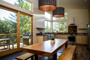 a kitchen with a wooden table and large windows at Alpenglow 1 in Yosemite West