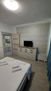 a bedroom with a white bed and a television at Apartament Matei in Tulcea