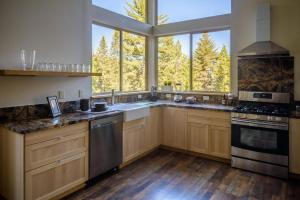 een keuken met houten kasten en een groot raam bij Alpenglow 3 in Yosemite West