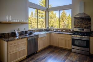 a kitchen with wooden cabinets and a large window at Alpenglow 3 in Yosemite West