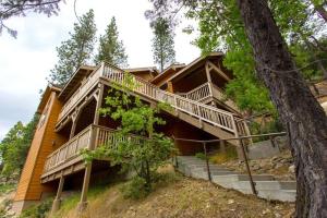 a large wooden house with stairs and a tree at Birds Eye Vista in Yosemite West