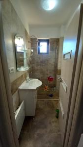 un bagno con un lavandino, uno specchio e una vasca di Apartament Matei a Tulcea Altre 7 foto