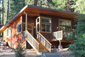 a cabin in the woods with a large deck at Alpenglow 2 in Yosemite West