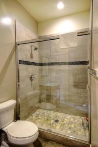 La salle de bains est pourvue d'une douche, de toilettes et d'une cabine de douche en verre. dans l'établissement Eureka, à Yosemite West