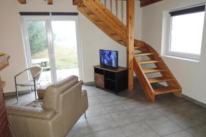 a living room with a staircase and a couch and a television at Holiday Home near Szczecin Lagoon in Szczecin +5 photos