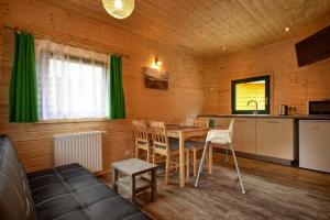 a room with a table and a kitchen with green curtains at Holiday homes, Pobierowo in Pobierowo