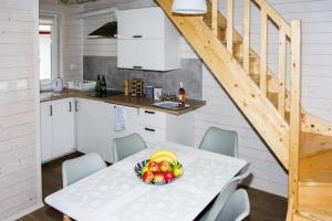 a kitchen and dining room with a table with a bowl of fruit at Terraced Houses, Dziwnow in Dziwnów