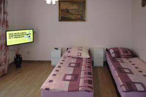 twee bedden in een kamer met een tv bij holiday home, Miedzyzdroje in Międzyzdroje