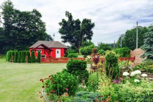 czerwony dom na środku ogrodu w obiekcie holiday home, Nowe Warpno w Nowym Warpnie