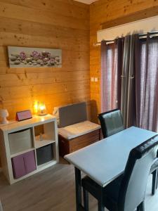 ein kleines Zimmer mit einem Tisch, einem Tisch und Stühlen in der Unterkunft Chez Stéphane et Emilie in Grenade-sur-Garonne