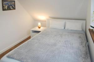um pequeno quarto com uma cama e uma mesa de cabeceira em holiday home, Stepnica em Stepnica