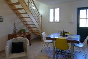 a room with a table and chairs and a staircase at Semi-detached house, Lancheres in Lanchères