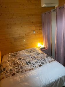Bett in einem Zimmer mit einer Holzwand in der Unterkunft Chez Stéphane et Emilie in Grenade-sur-Garonne