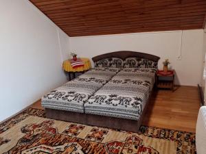 um quarto com uma cama num quarto com um tapete em Napsugar Nyaraló em Fonyód