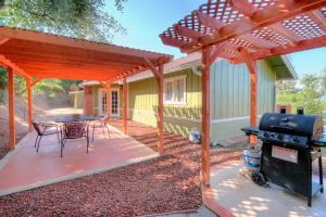 Un patio con parrilla y mesa y sillas. en Harmony Hilltop Hideaway, en Oakhurst