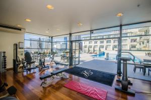 een fitnessruimte met een grote kamer met een zwembad bij Sky Tower Serenity + Rooftop Pool in Auckland