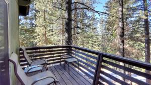 a porch with three chairs and a table on it at Hawks Nest Lodge in Yosemite West