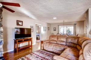 ein Wohnzimmer mit einem Sofa und einem Flachbild-TV in der Unterkunft Lazy Bear Lodge in Oakhurst