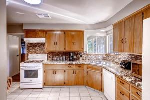 a kitchen with wooden cabinets and white appliances at Lazy Bear Lodge in Oakhurst