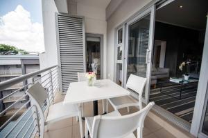 a white table and chairs on a balcony at Stays With DMWA in Johannesburg