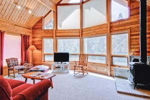 a living room with a large room with windows at Red Fox Retreat in Yosemite West