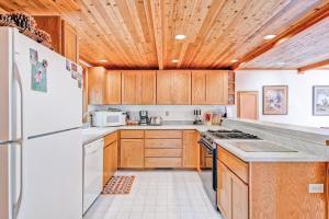 a kitchen with a white refrigerator and wooden cabinets at Red Fox Retreat in Yosemite West