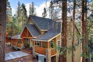 a house with a deck in the woods at River Rock Retreat in Yosemite West