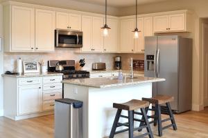 a kitchen with white cabinets and a stainless steel refrigerator at River Rock Retreat in Yosemite West
