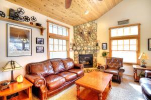 sala de estar con muebles de cuero y pared de piedra. en Strawberry Creek, en Yosemite West