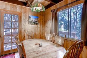 a dining room with a wooden table and windows at Skyline Retreat in Yosemite West