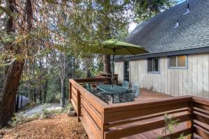 a wooden deck with a table and an umbrella at Skyline Retreat in Yosemite West