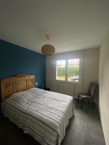 a bedroom with a bed and a chair and a window at Cool Landes in Sainte-Eulalie-en-Born