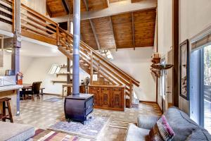 a living room with a fireplace and a staircase at Yosemite's Creekside Birdhouse in Wawona