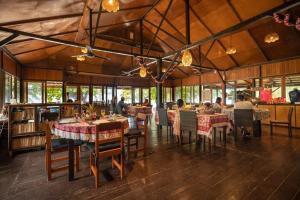 um restaurante com mesas e cadeiras e pessoas sentadas a eles em Murex Bangka Dive Resort em Likupang