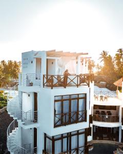 a white house with a balcony and a pool at Pili Pili Tropical Island in Jambiani