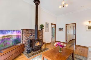 a living room with a fireplace and a tv at Divine Cottage - Main Street Bangalow in Bangalow